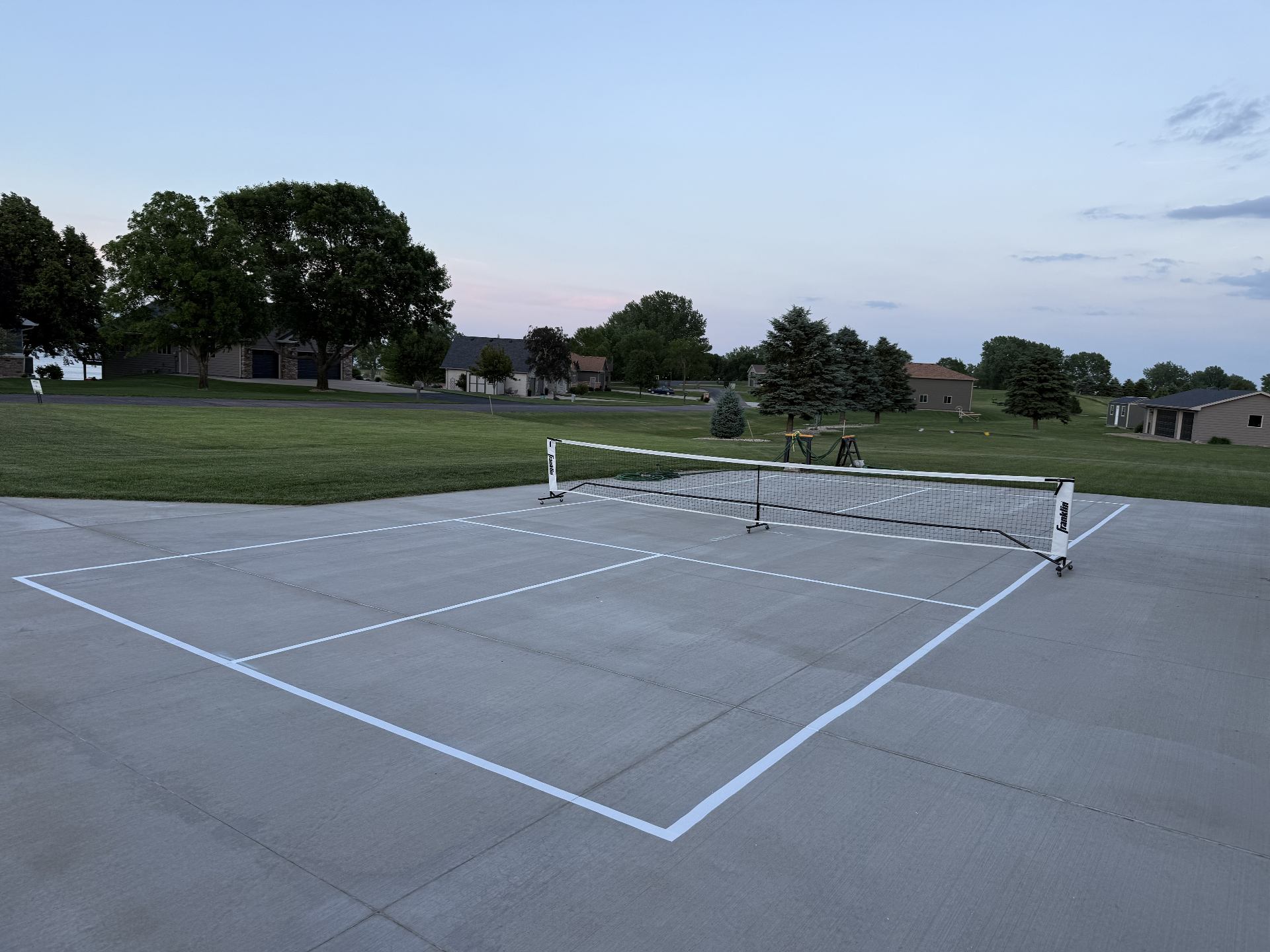 Completed pickleball court with fresh white lines painted on a concrete driveway in Sioux Falls