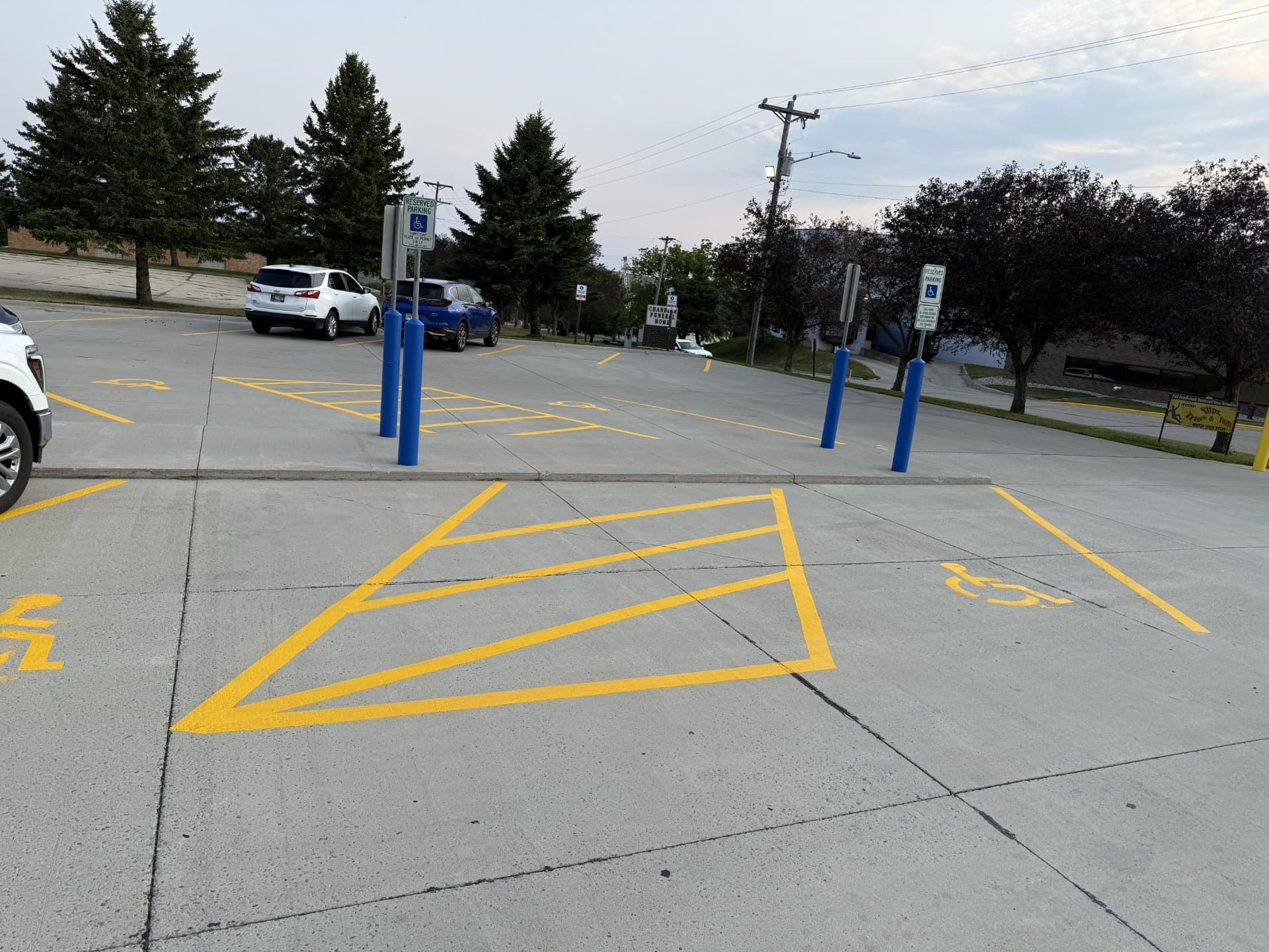 Freshly striped ADA accessible parking stalls with yellow access aisles, wheelchair symbols, and reserved parking signs on a Sioux Falls commercial lot